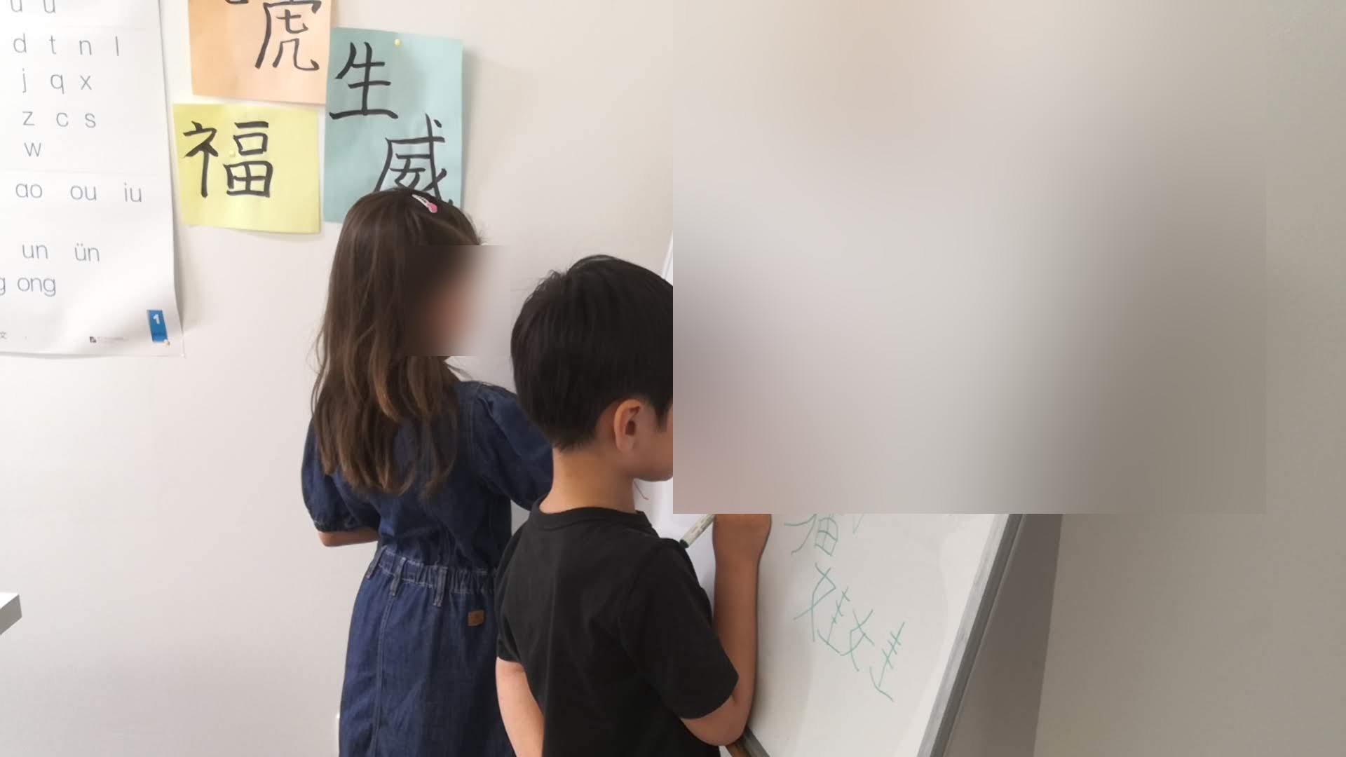 Enfants apprenant les caractères chinois au tableau pendant un cours de mandarin